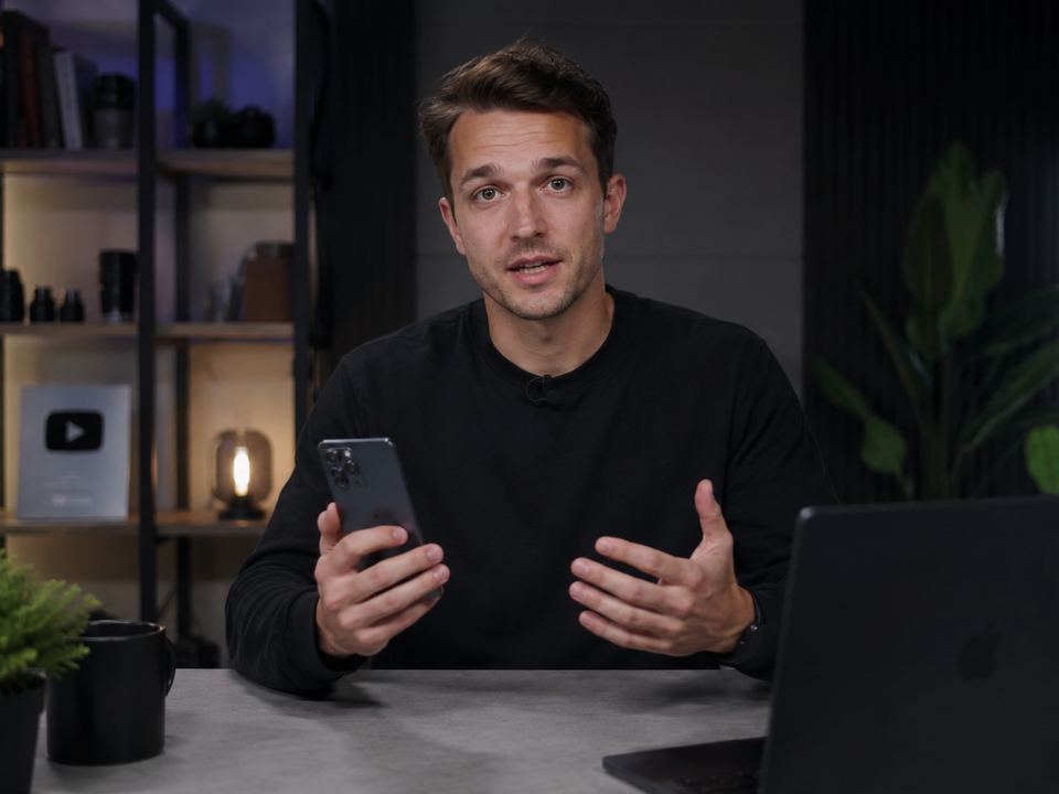 Someone at a desk holding up a product to camera